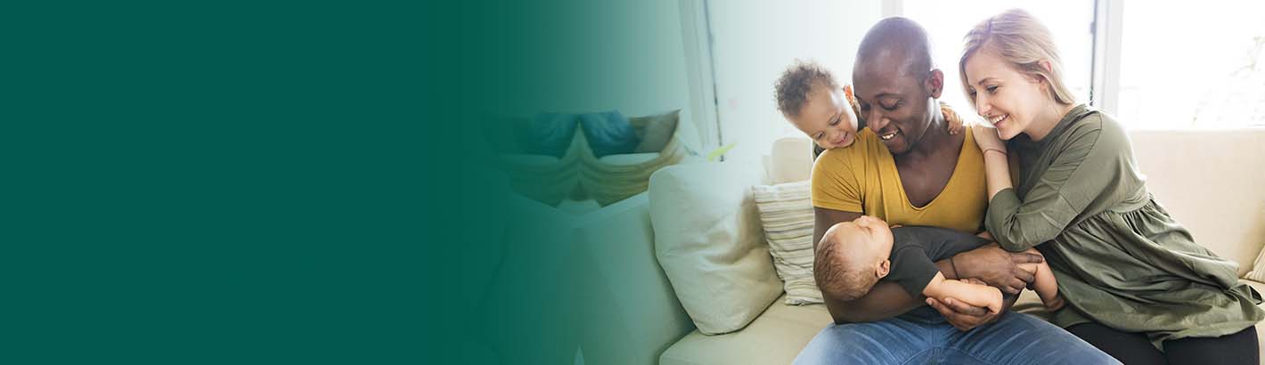 Family with 2 young children sitting on a couch